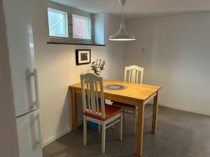 a kitchen with a wooden table and chairs and a refrigerator at Villa Room in Malmö +2 photos