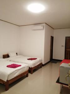 two beds in a room with white walls at ชมวิว บึงโขงหลง in Ban Don Klang