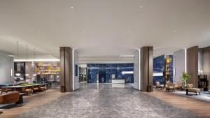 a lobby of a building with tables and chairs at Crowne Plaza Weihai Binhai by IHG in Weihai +74 photos
