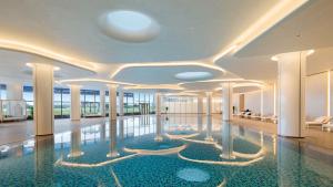 a swimming pool in a building with a lobby at Crowne Plaza Weihai Binhai by IHG in Weihai
