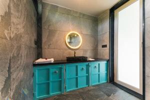 a bathroom with a blue cabinet and a mirror at Hidden Gem near Jaipur horse ride, scenic view & swimming pool in Pachār +18 photos