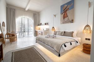 サヌールにあるMaison Boheme Modern Apartment & Villa with Pool in Sanurの壁に絵が飾られた大きなベッドのある寝室