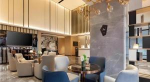 a hotel lobby with chairs and tables and a television at Echarm Hotel Shenyang Zhongjie North Station Metro Station in Shenyang