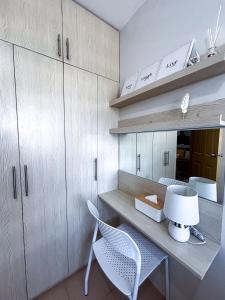 uma cozinha com uma escrivaninha, duas cadeiras e armários em A Sleek Spacious Escape em Iloilo City