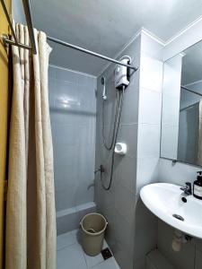 uma pequena casa de banho com um chuveiro e um lavatório. em A Sleek Spacious Escape em Iloilo City