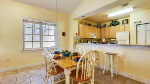 ストック・アイランドにあるPlace to Relax by AvantStay Shared Pool 3 Miles to Smathers Beach Month-Long Stays Onlyのキッチン(テーブル、椅子、カウンター付)