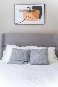 a bed with two pillows and a picture of a guitar at Landing Spectacular 1BD Pool Gym in West Baton Rouge +16 photos