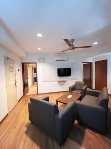 a living room with a couch and a tv at My Hotel Bukit Mertajam in Bukit Mertajam