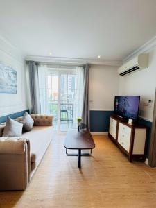 a living room with a couch and a tv at Seven Seas Cote D'azur Resort Jomtien in Na Jomtien