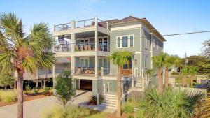 a large house with palm trees in front of it at 311 Carolina by AvantStay Rooftop Ocean Views w Pool in Mount Pleasant