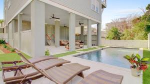 a house with a swimming pool and two lawn chairs at 311 Carolina by AvantStay Rooftop Ocean Views w Pool in Mount Pleasant