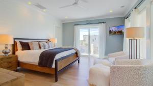 a bedroom with a bed and a chair and a window at 311 Carolina by AvantStay Rooftop Ocean Views w Pool in Mount Pleasant +32 photos