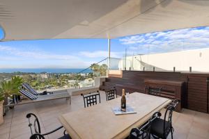 Una mesa y sillas en un balcón con vista. en Noosa Crest Penthouse 34 - Private Rooftop Pool, en Noosa Heads