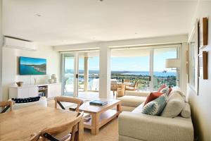 una sala de estar con un sofá y una mesa en Noosa Crest Penthouse 34 - Private Rooftop Pool, en Noosa Heads
