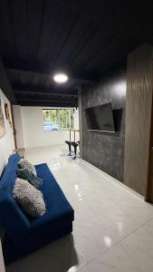 a living room with a blue couch and a flat screen tv at Apartahotel crucero plaza naturaleza y confort en Pereira in Pereira