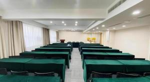 a conference room with green chairs and a podium at GreenTree Inn Luoyang Railway Station Wangfujing Wangcheng Park in Luoyang
