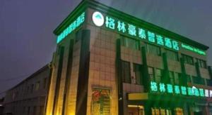 Un edificio con un reloj en el costado. en GreenTree Inn Express Shandong Qingdao Chengyang District Aodong Road, en Qingdao