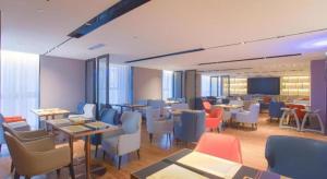 a restaurant with tables and chairs in a room at Echarm Hotel Nanning the MixC Dongmeng Business District in Nanning
