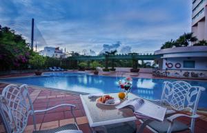 a pool with a table with a bowl of fruit on it at Halong Plaza Hotel in Ha Long