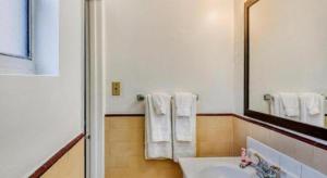 a bathroom with a sink and a mirror and towels at OYO Gateway Motel Las Vegas North Strip/Fremont St. Area in Las Vegas