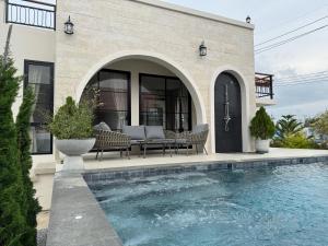 a house with a swimming pool in front of a house at The Lush Valley Khao yai in Ban Bung Toei