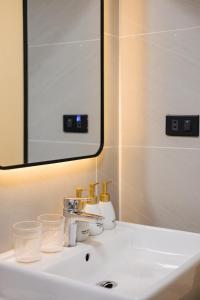 a bathroom sink with a mirror and a white sink at Willow Trackside Apartment in Hanoi