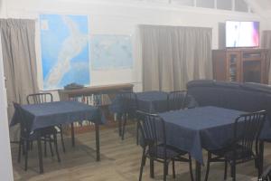 a classroom with blue tables and chairs and a screen at Riverside Haven Lodge & Holiday Park in Waianakarua