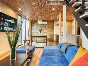 a living room with a blue couch and a table at Rakuten STAY VILLA Lake Yamanakako 105 in Yamanakako