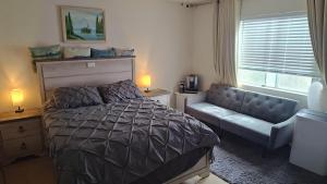 a bedroom with a bed and a couch and a window at Golden House in Santa Clarita