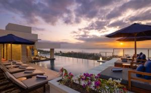 a restaurant with a view of the ocean at sunset at Bali Tropic Resort & Spa - CHSE Certified in Nusa Dua