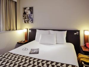 a large bed with a black and white checkered blanket at Hôtel Mercure Lyon Centre Lumière in Lyon