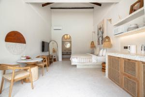 サヌールにあるMaison Bohemeのベッドとテーブルと椅子のある寝室