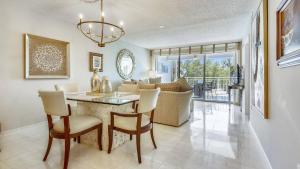 a dining room and living room with a table and chairs at Dune Wind South by AvantStay Communal Pool Hot Tub Gated Community Close to Smathers Beach Month Long Stays Only in Key West