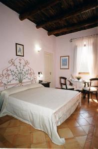 a bedroom with a large bed and a dining room at Hotel Casale 900 in Paestum