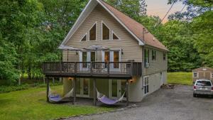 a house with two hammocks in front of it at Alpine Serenity by AvantStay Beach Lake Access Theater Deck Playroom in Albrightsville