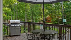 a grill on a deck with a table and chairs at Alpine Serenity by AvantStay Beach Lake Access Theater Deck Playroom in Albrightsville