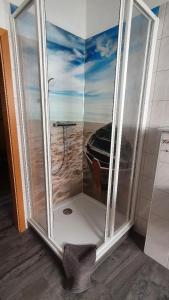 a shower with a picture of a boat in the ocean at Villa Amilia - Ferienwohnung 2 in Waren
