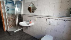 a bathroom with a sink and a shower and a toilet at Villa Amilia - Ferienwohnung 2 in Waren +7 photos