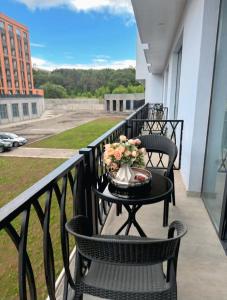 a table with a vase of flowers on a balcony at Apartment tsaghkadzor SHINE HOME in Tsaghkadzor