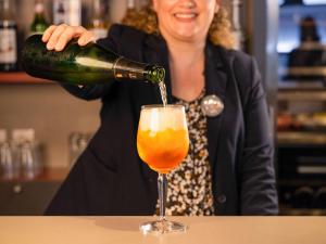 Eine Frau, die einen Drink in ein Glas gießt. in der Unterkunft Mercure Tours Nord in Tours