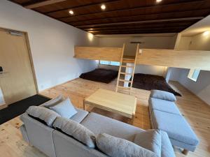 salon z kanapą i łóżkiem piętrowym w obiekcie 宿場を眺める古民家宿陽屋-Hinataya- w mieście Nakatsugawa