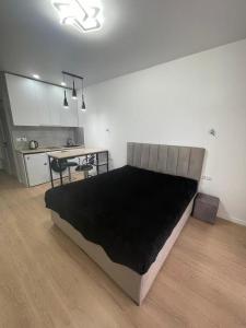Una cama grande en una habitación con cocina. en Seaview studio apartment, en Gonio
