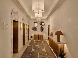 a hallway with a long hallway with a table and a hallway sidx sidx at The Brighton Hotel Sydney - Mgallery Collection in Sydney