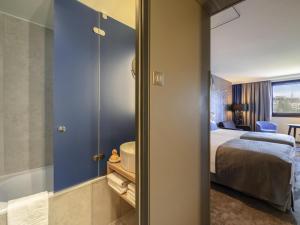 a hotel room with a bed and a bathroom at Mercure Budapest Castle Hill in Budapest