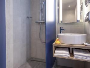 a bathroom with a sink and a shower at Mercure Budapest Castle Hill in Budapest +99 photos