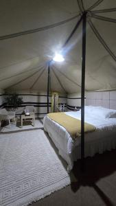 Un dormitorio con una cama en una tienda de campaña. en Arabian Desert nights, en Badīyah