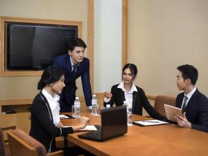 un grupo de personas sentadas alrededor de una mesa en Novotel Bangkok Bangna, en Bangna