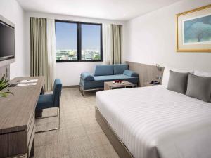 una habitación de hotel con una cama y una silla en Novotel Bangkok Bangna, en Bangna