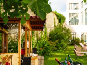 Una pérgola de madera con botellas sobre una mesa. en Mercure Bordeaux Chateau Chartrons, en Burdeos