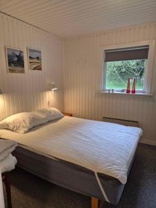 a bedroom with a large bed with a window at Unobstructed Summer House In Lovely Langeland in Tranekær